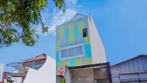 Ein modernes Gebäude mit farbenfroher Fassade, einem verschlossenen Eingang und geparkten Autos.