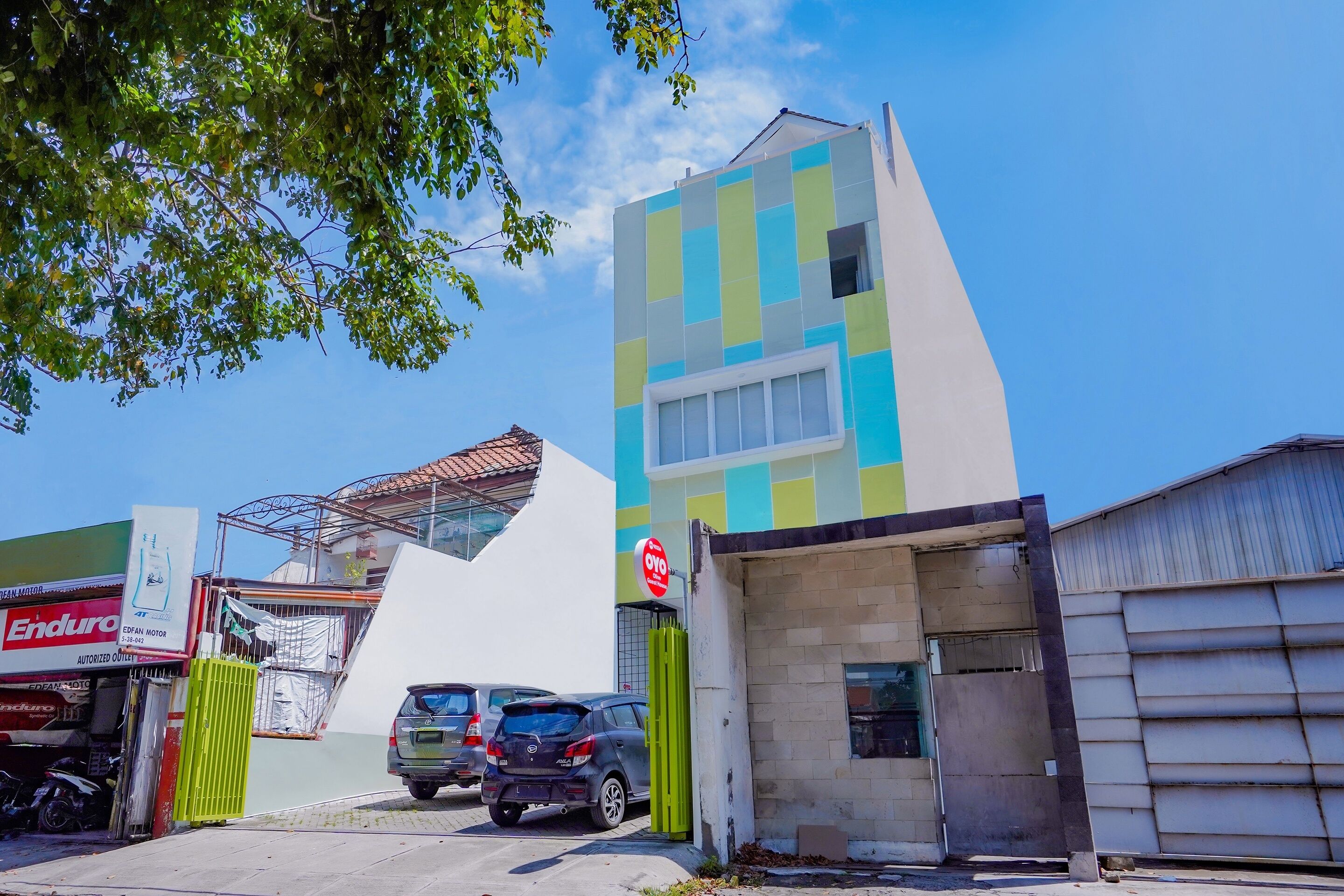 A building with a modern design, featuring a mix of geometric shapes and a prominent blue and green color scheme.
