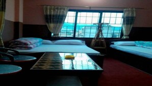 Une chambre avec deux lits, une table et une chaise.