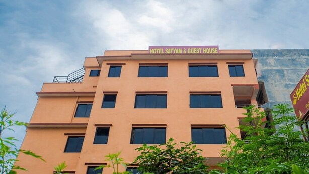 Un hôtel appelé « Hotel Satyam & Guest House », doté d’une architecture moderne, avec de nombreuses fenêtres et des balcons.