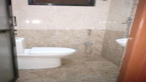 Une salle de bain avec des toilettes, un lavabo et une douche.