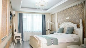 Un dormitorio elegante con una cama grande, una mesita de noche y una araña.