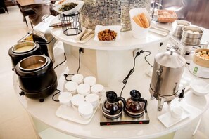 A buffet setup with various food items and cooking equipment. - Tianhe Hotel (Huinan)