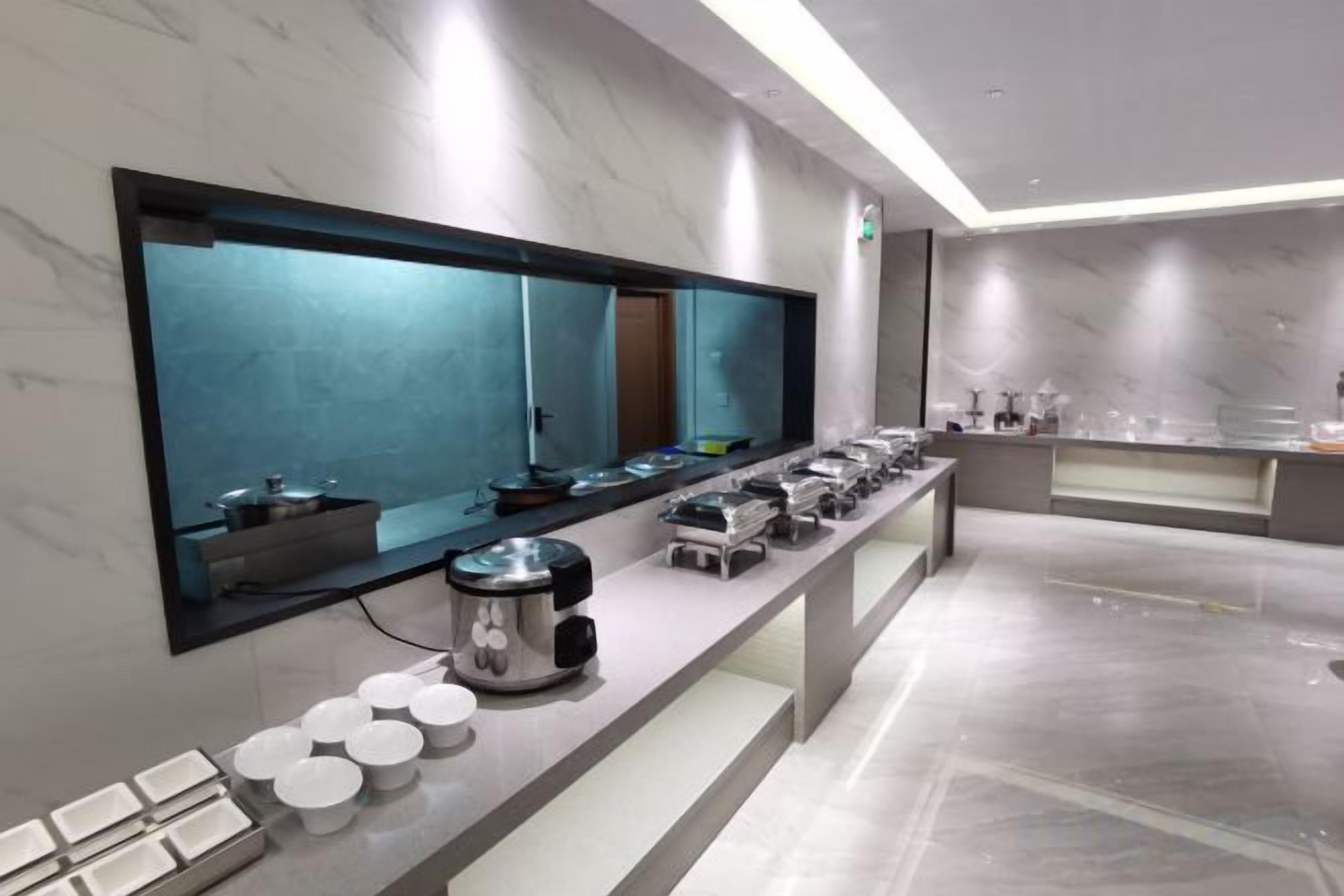 A modern bathroom with a large mirror, a countertop with toiletries, and a sink.