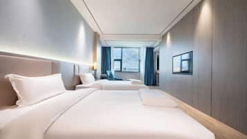 A hotel room with two beds, a large window, a view of the city, and a modern design.