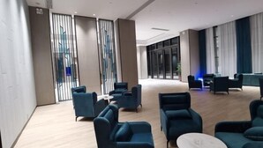 Un vestíbulo amplio con asientos modernos y un ventanal que ofrece vistas de la ciudad.