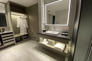 Een moderne badkamer met een wastafel, spiegel en ingebouwde planken.