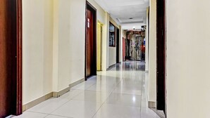 A hallway with doors on both sides, a tiled floor, and a metal gate at the end.