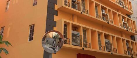 A multi-story building with balconies and a garage entrance.