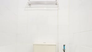 Eine Toilette mit weißem Tank und Sitz, einem blauen Schlauch und einem gefliesten Boden mit Muster.