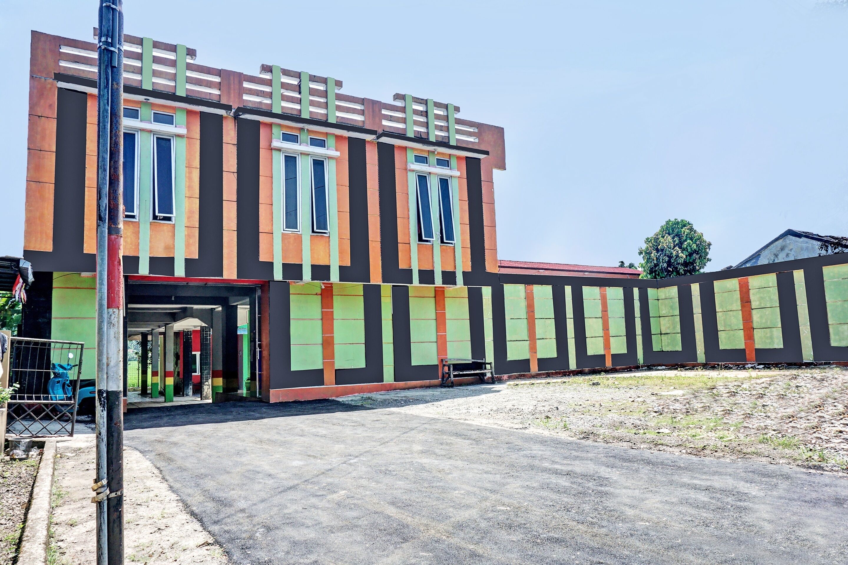 Un bâtiment doté d’une façade moderne, de grandes fenêtres et d’un espace d’entrée abrité.