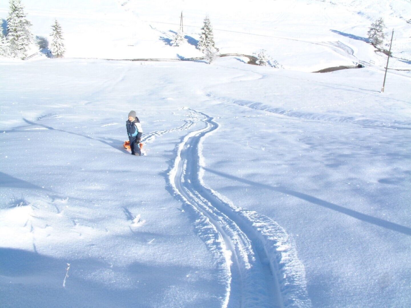 Schneelandschaft mit einer einzelnen Person beim Skifahren.