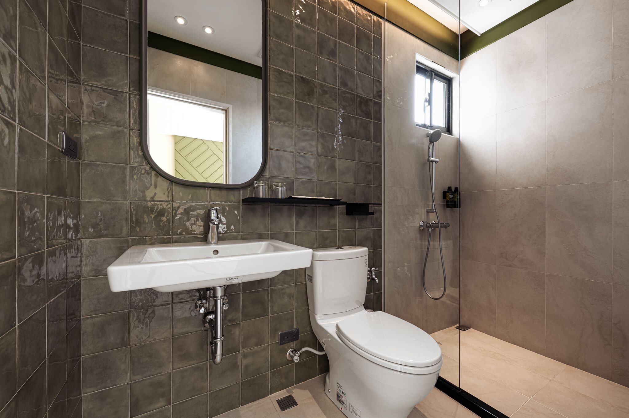 A modern bathroom with a white sink, toilet, and shower.