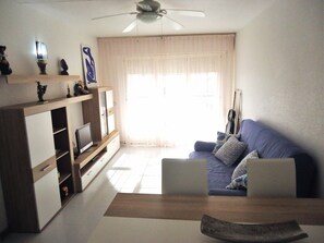 Relax in this stylish living room with a sofa, coffee table, and flat-screen TV.