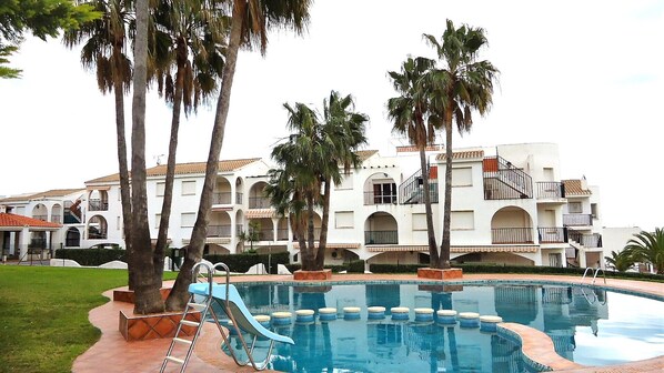 Relax by the pool surrounded by palm trees and enjoy the hotel's arched windows and tiled roof.