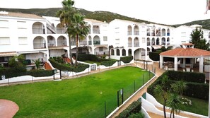 Stroll through the serene courtyard surrounded by beautifully maintained gardens and palm trees.