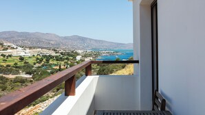 A balcony with a wooden railing overlooking a coastal landscape with mountains and a body of water. - Sea views, short drive to the beach and shops! (Agios Nikolaos)