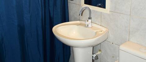 A bathroom with a white sink, a blue shower curtain, and a mirror above the sink.
