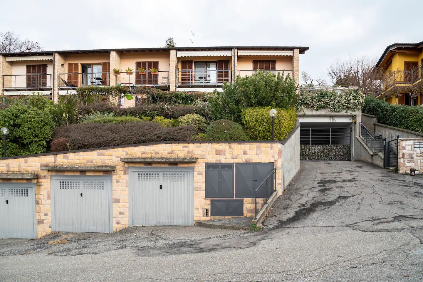 A two-story building with a garage and a covered driveway.