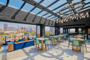 A rooftop restaurant with a city view, modern design, and outdoor seating. - The Godfrey Detroit, Curio Collection By Hilton (Detroit)