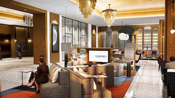 A modern hotel lobby with seating areas, a reception desk, and a bar.