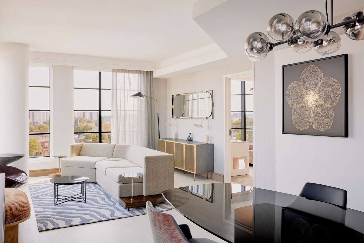 A modern living room with a sofa, coffee table, and dining area.