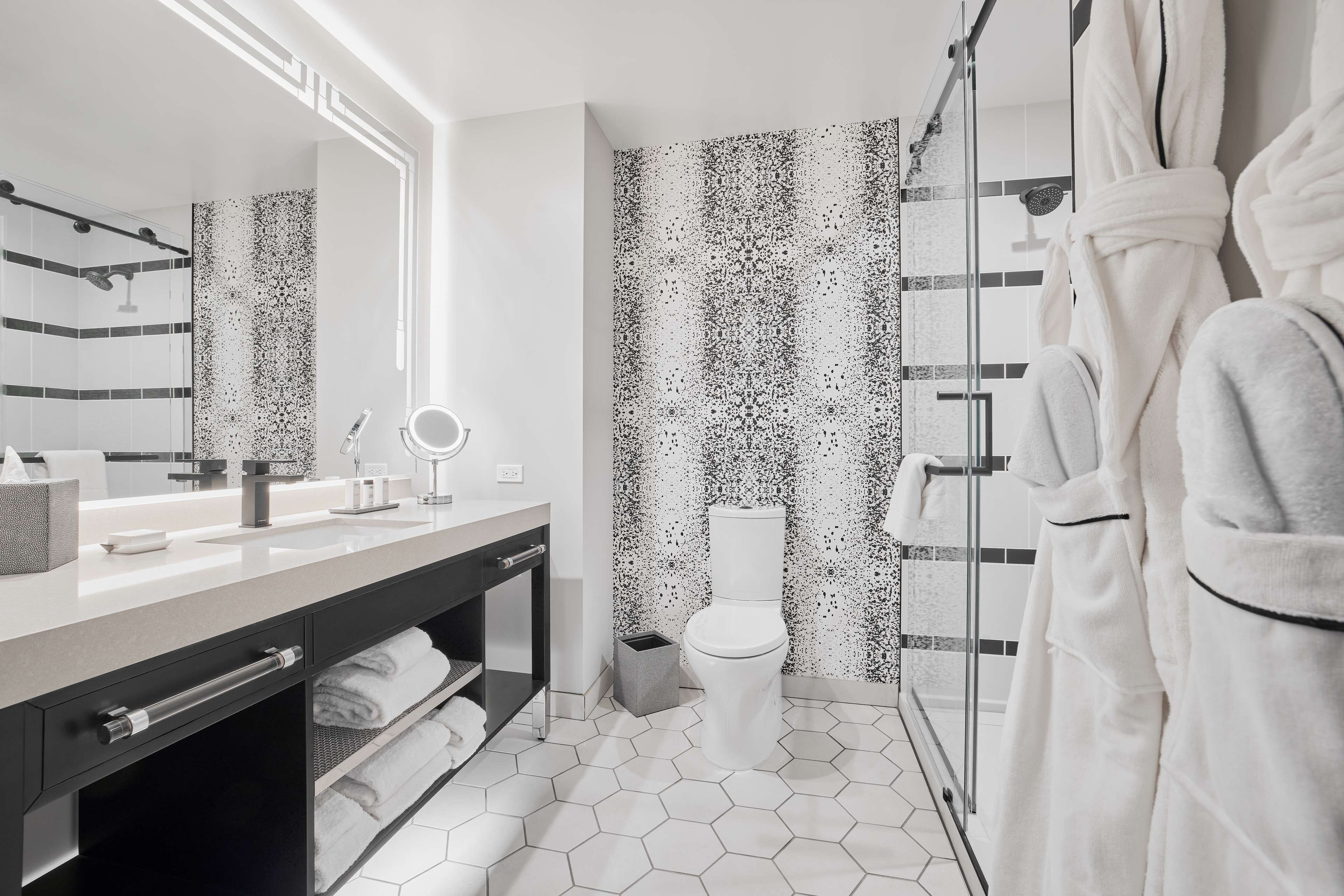 A modern bathroom with a large mirror, a toilet, and a shower area.