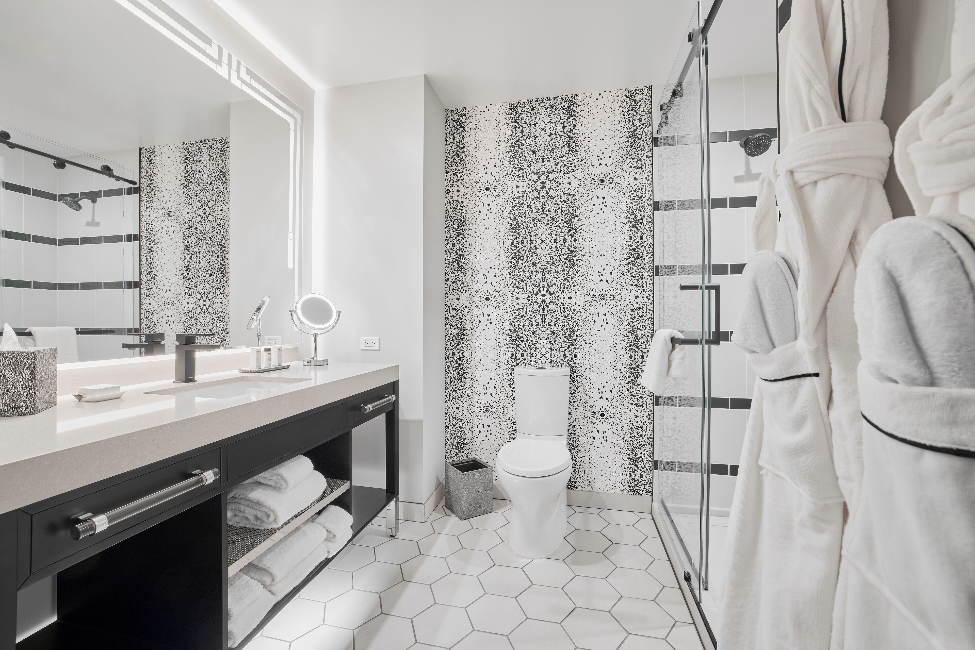A modern bathroom with a large mirror, a toilet, and a shower area.