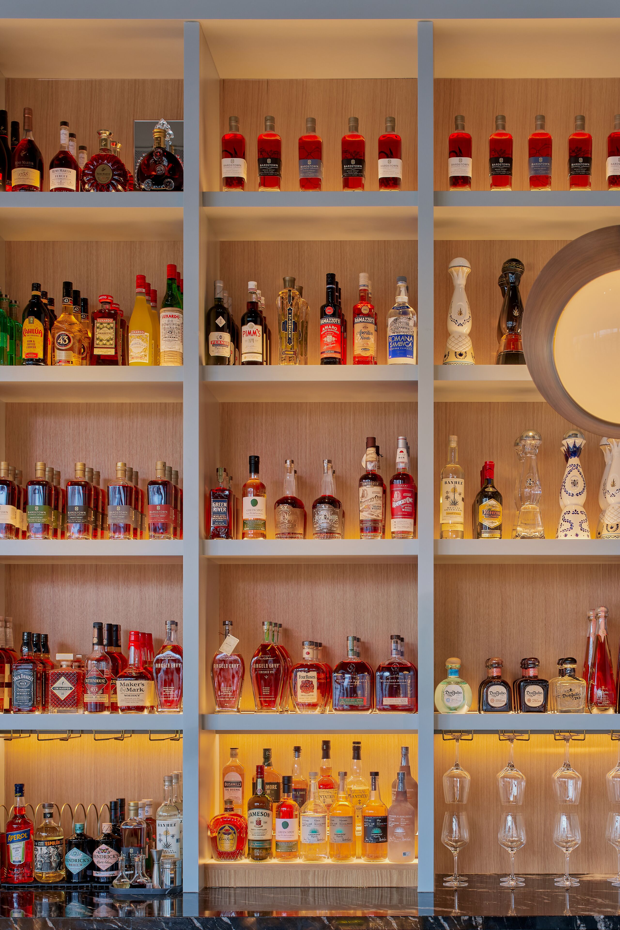 A liquor store with multiple shelves of various alcohol bottles and glasses.