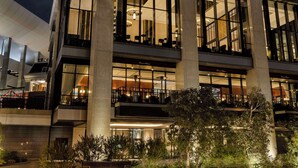 A modern hotel with a prominent Hilton sign, multiple floors, and a well-lit facade.
