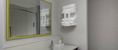 A bathroom with a white sink, a mirror with a yellow frame, and a towel rack.