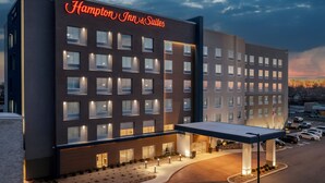 A Hampton Inn & Suites hotel with a modern facade, multiple windows, and a well-lit entrance area. - Hampton Inn & Suites Indianapolis West Speedway (Indianapolis)