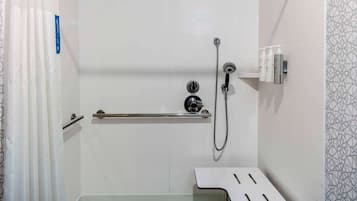 A shower with a handheld showerhead, a handheld showerhead, and a handheld showerhead.