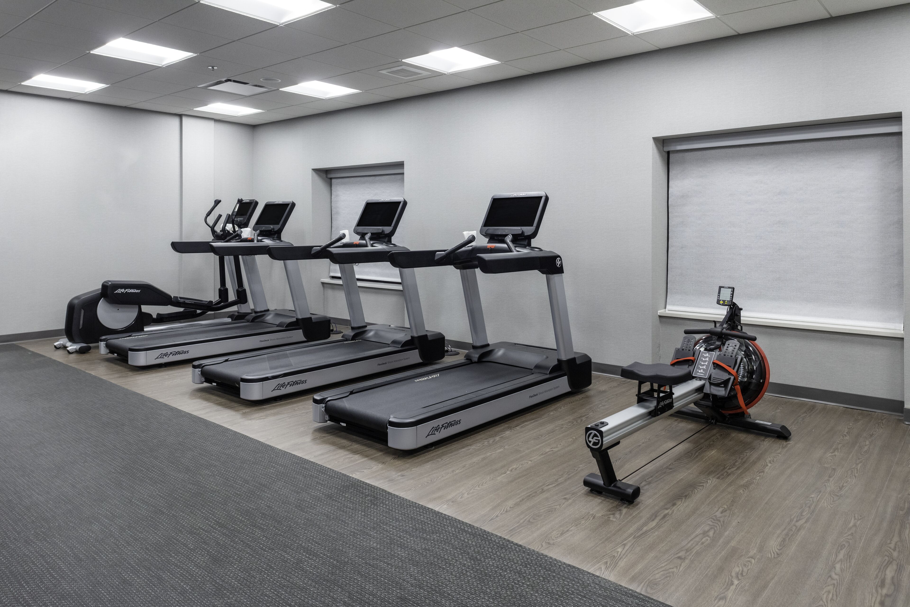A fitness room with treadmills, a rowing machine, and a stationary bike.