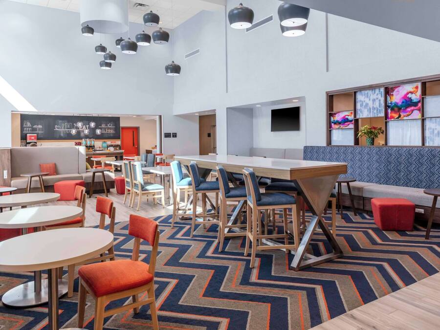 A modern lounge area with multiple seating options including tables, chairs, and a sofa.
