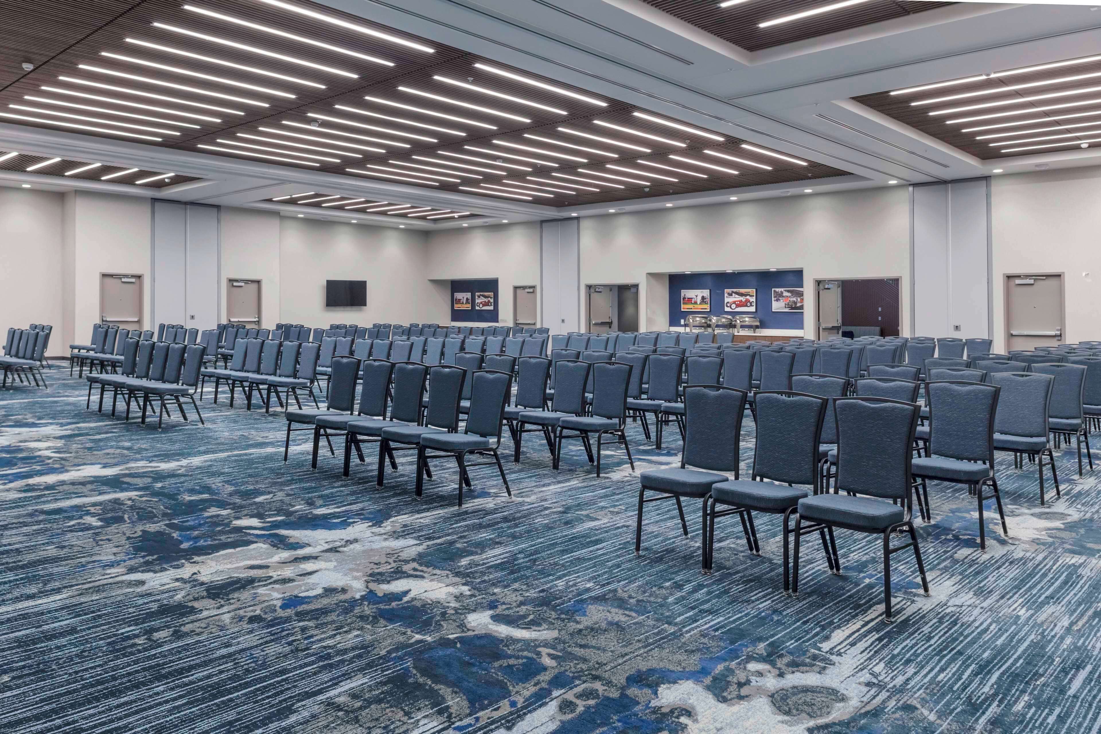 A large conference room with rows of chairs and a carpeted floor.