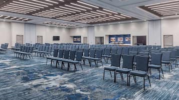 A large conference room with rows of chairs and a carpeted floor.