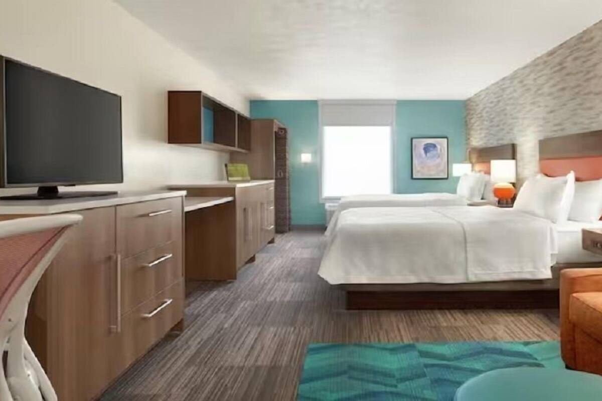 Une chambre d’hôtel avec un lit, une télévision, un bureau et un canapé.