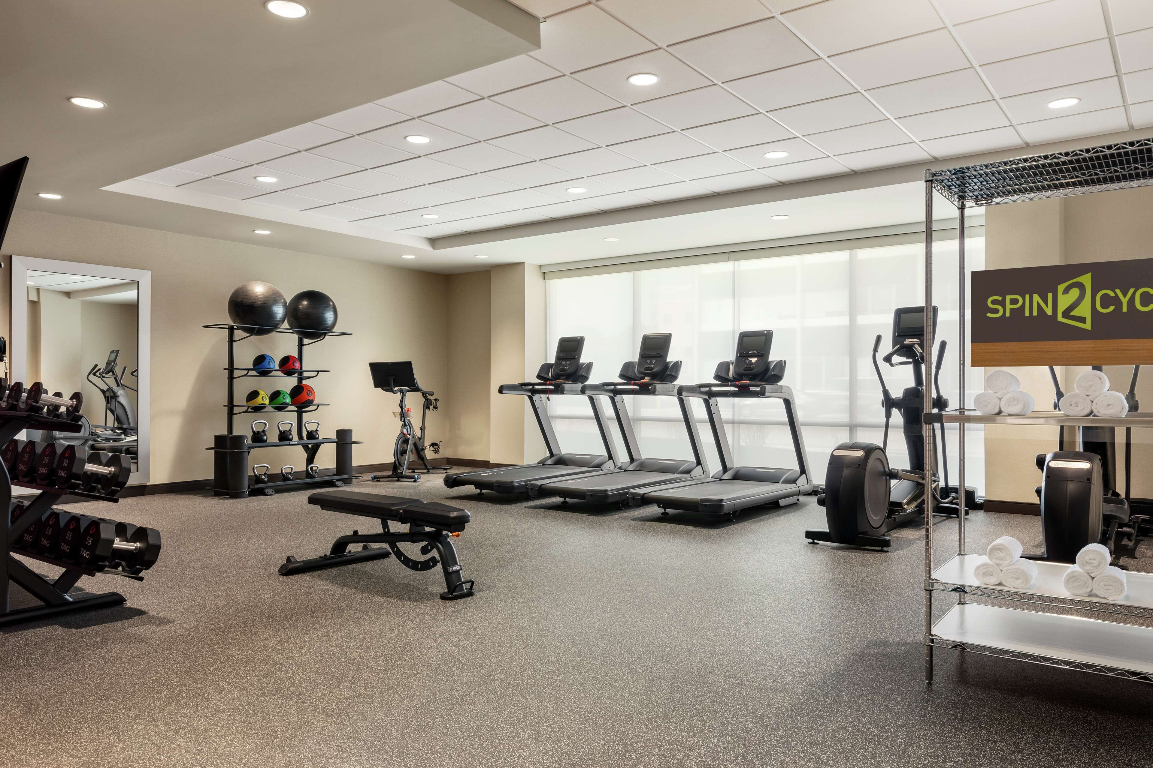 Un gimnasio con cintas de correr, pelotas de ejercicios y máquinas de pesas.