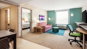 Une chambre d’hôtel équipée d’un lit, d’un canapé, d’un bureau et d’une télévision.