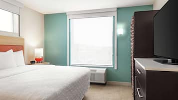 Una habitación de hotel con cama, televisión, ventana y calefacción.