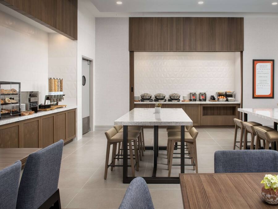 Une cuisine moderne dotée d’un îlot central, de tabourets de bar et d’un comptoir pour prendre le petit-déjeuner.