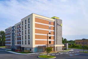 A multi-story hotel with a brick facade, a prominent 'HOME2' sign, and a parking lot with a handicap parking space. - Home2 Suites By Hilton Richmond Glenside (Richmond)