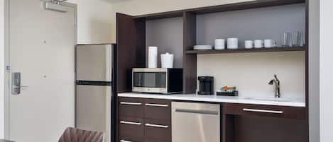 A compact kitchen with a microwave, coffee maker, and dishwasher.