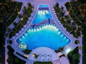 An aerial view of a resort with a large swimming pool, sun loungers, and palm trees. - The Mermoon Resort Hainan Tufu Bay, Tapestry By Hilton (Lingshui)