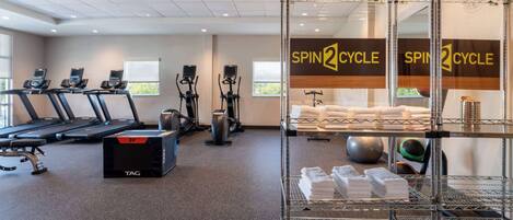 Un gimnasio con cintas de correr, elípticas y una zona de ciclismo indoor.