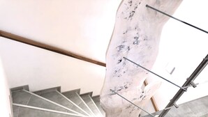 A staircase with a marble wall and metal handrails.