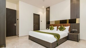 Una habitación de hotel moderna con una cama grande, una mesita de noche, un armario y una puerta.