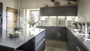 Una cocina moderna con gabinetes grises, electrodomésticos de acero inoxidable y una isla grande con un cesto de pan.