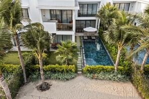 A modern hotel with a rooftop pool, surrounded by palm trees and lush greenery. - Angsana Ho Tram (Ho Chi Minh City)